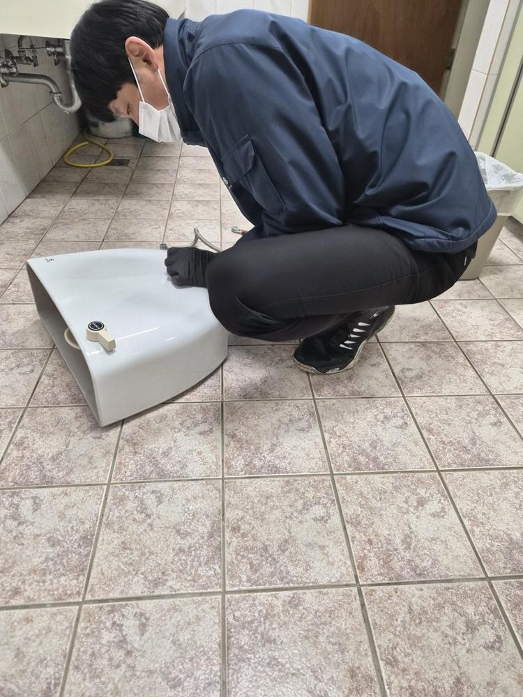 분리한 변기 뚜껑 옆에서 작업하는 모습